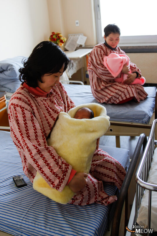 Cozy women in traditional robes enjoying a serene moment in Pyongyang, North Korea.