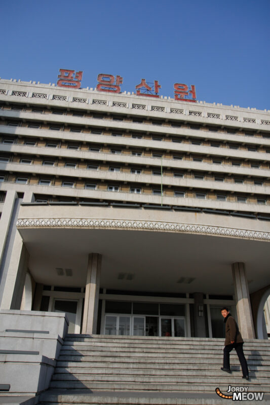 Discovering iconic Pyongyang building with Korean script sign, showcasing cultural significance.
