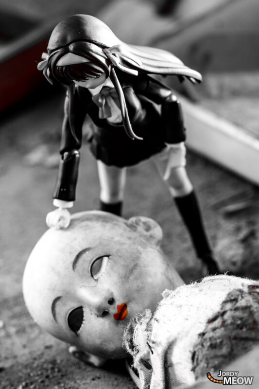 Black-and-white doll figurine examines cracked doll head in abandoned Japanese clinic, Gifu