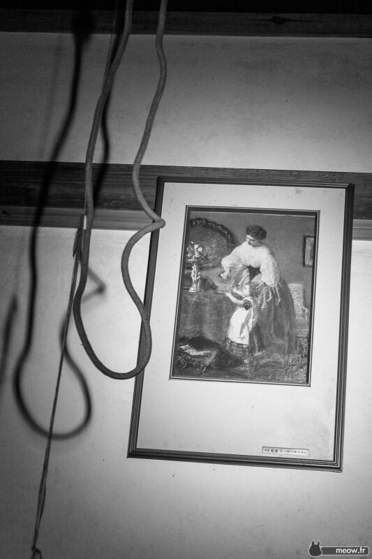 Black-and-white wall with hanging cords and framed mother-and-child artwork