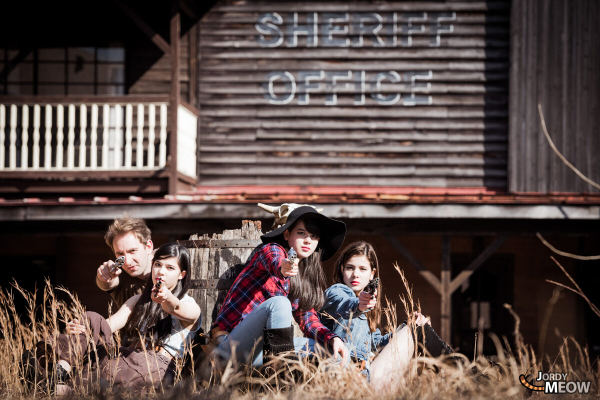 Urban exploration of abandoned Western theme park with rustic buildings and neon SHERIFF OFFICE sign.