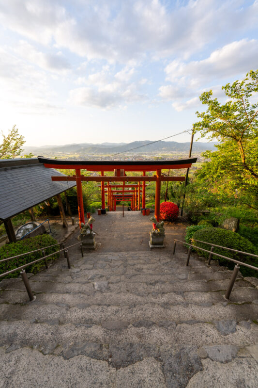 Stone staircase through vermilion torii gates at Ukiha Inari Shrine, Japan