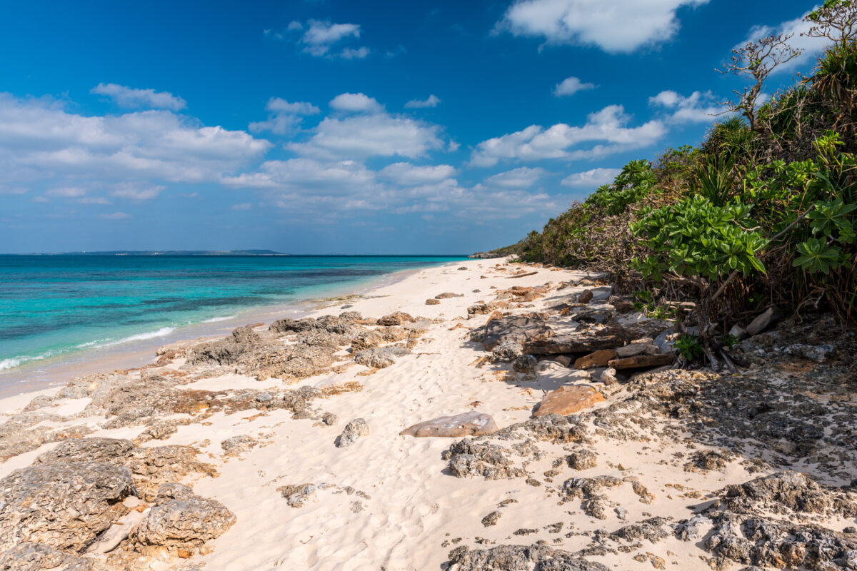 Turquoise shoreline with limestone rocks and sandy beach on Miyako Island, Japan