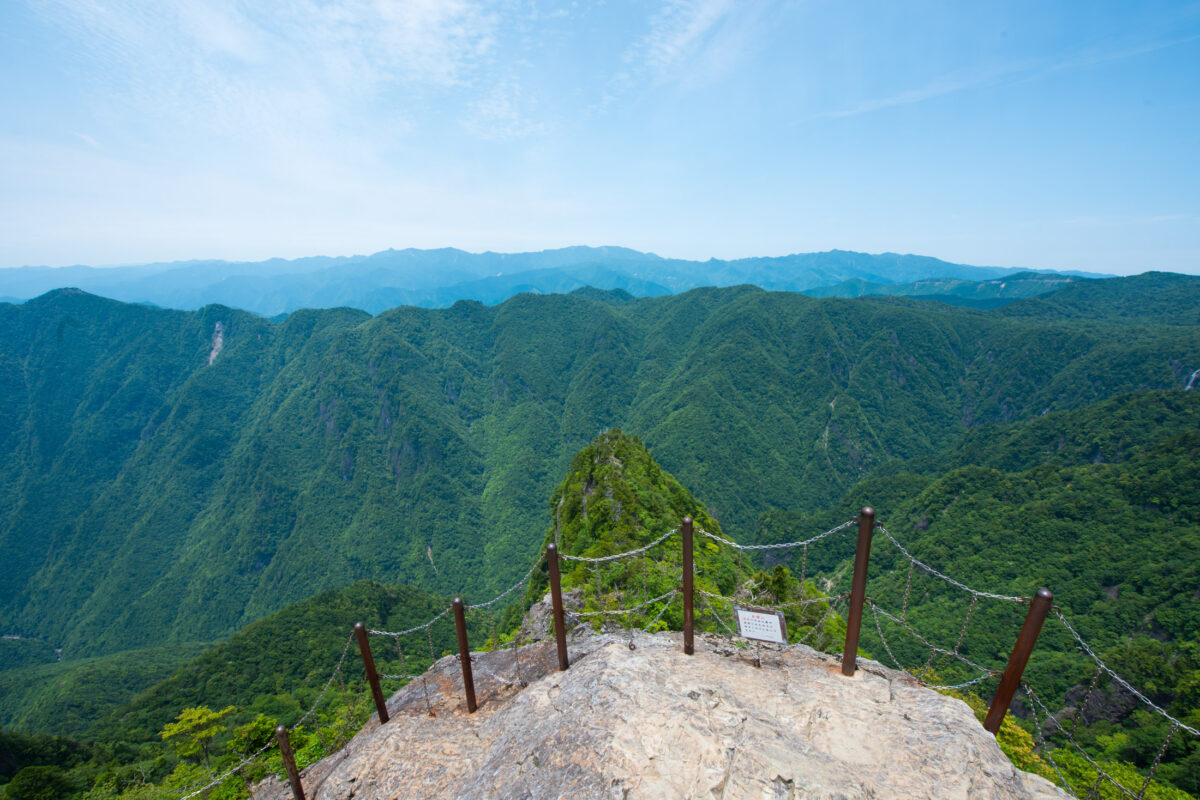 Mount Odaigahara summit lookout with chain railing over forested mountain ridges, Japan