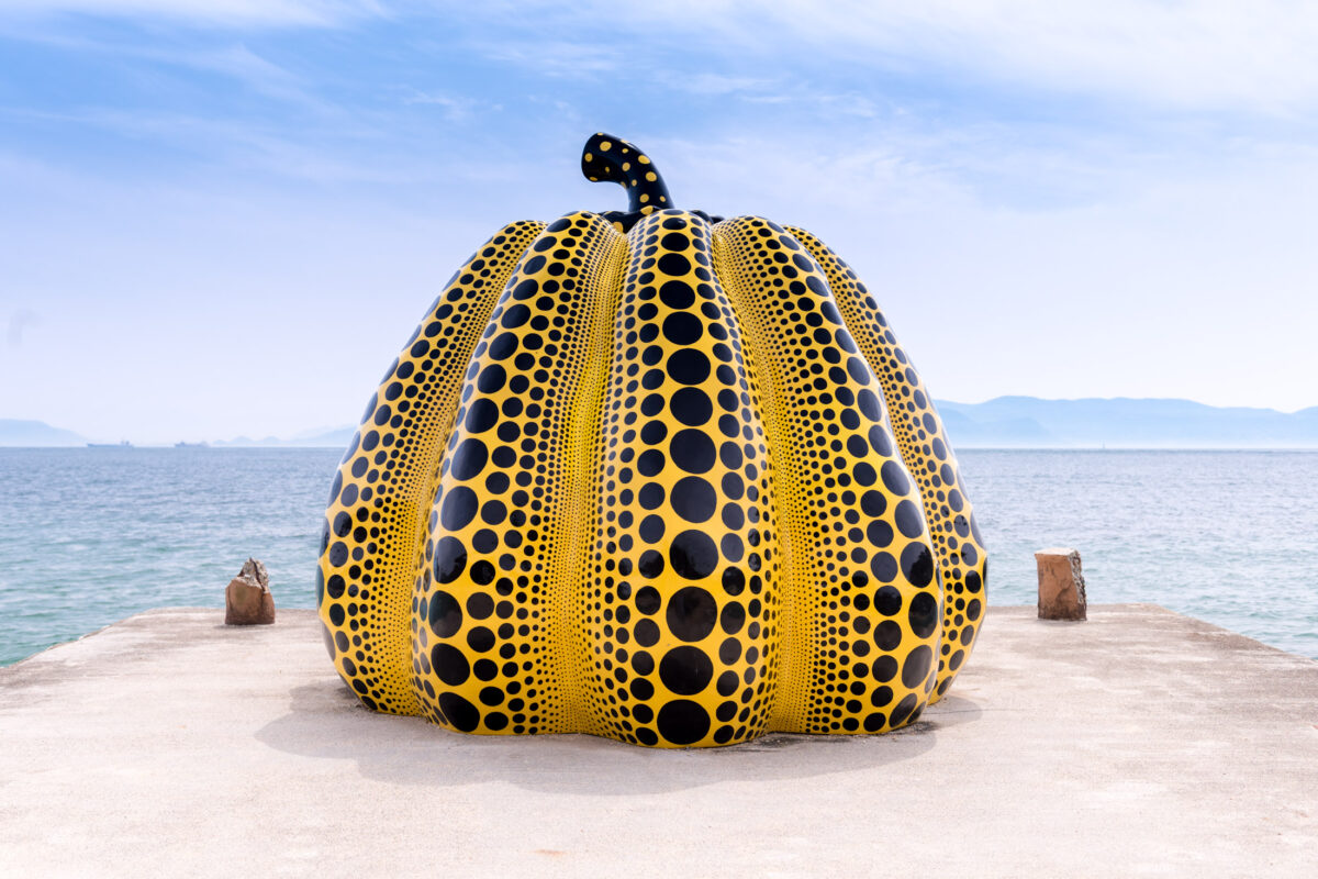 Yayoi Kusama yellow polka dot pumpkin sculpture on Naoshima pier overlooking the sea