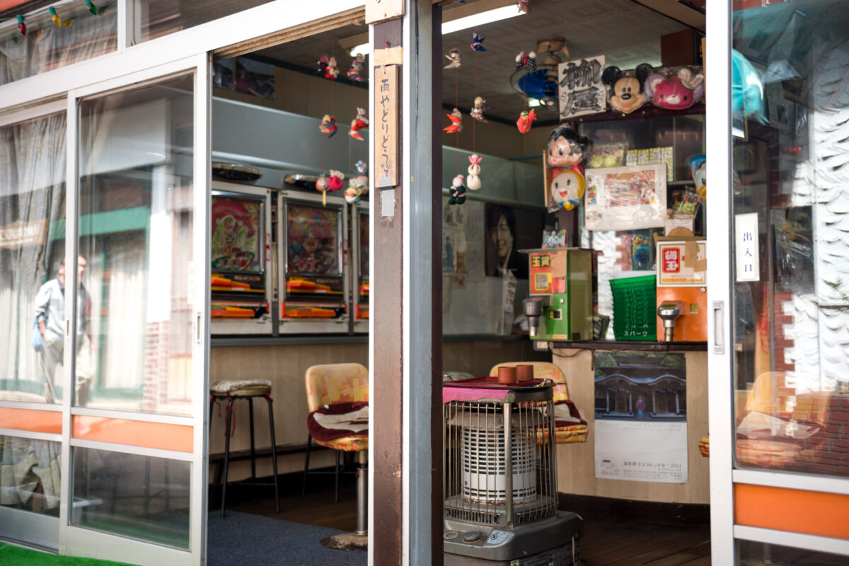 Cozy Sekizenkan Ryokan interior with heater, floor cushions, and vintage Japanese decor through glass doors.