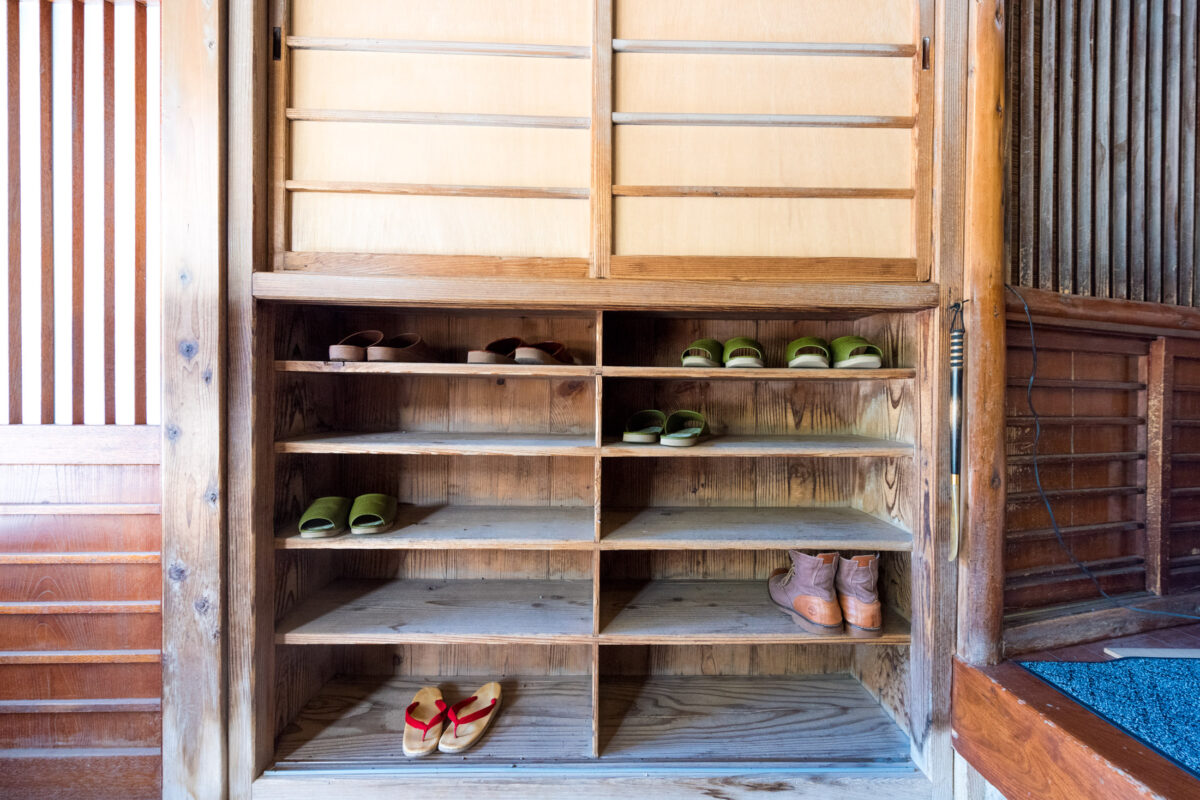 Traditional wooden shoe rack with slippers at Sekizenkan Ryokan entrance, Japan