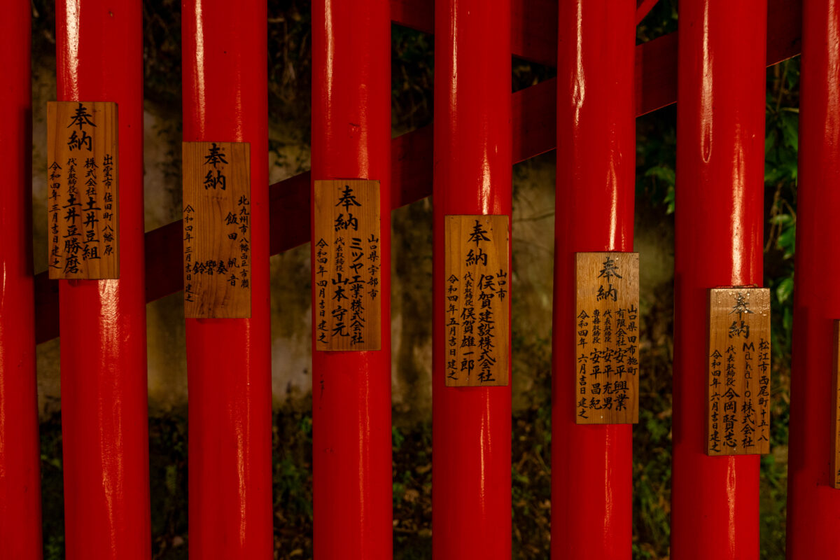 Vermilion torii posts with Japanese prayer plaques at Taikodani Inari-jinja Shrine, Japan