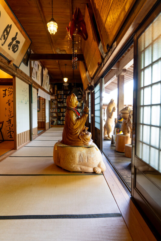 Unrin-ji Temple corridor with tatami mats, Buddhist statues, and shoji-lit wooden interior.