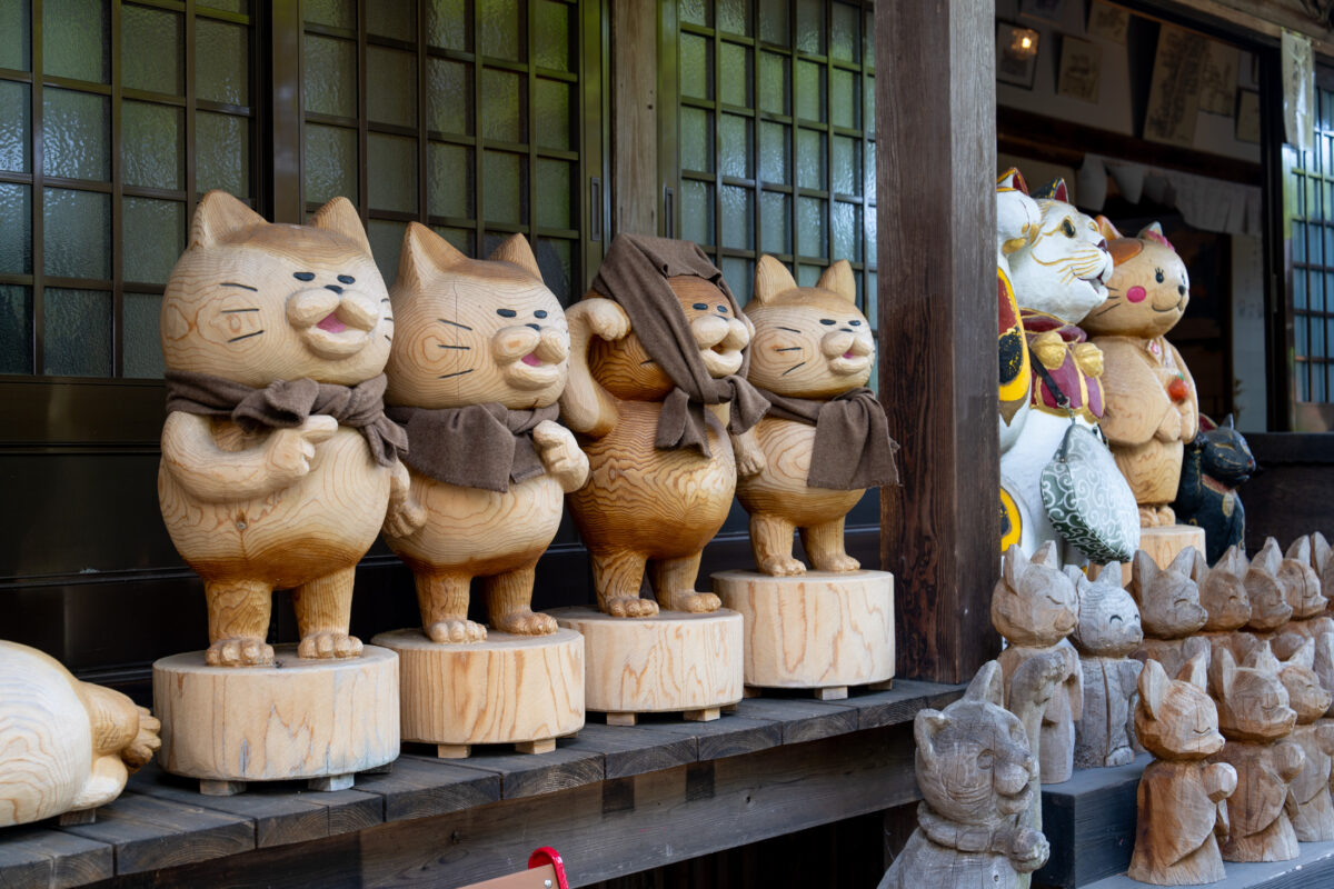 Wooden cat guardian statues lined on Unrin-ji Temple veranda in Japan