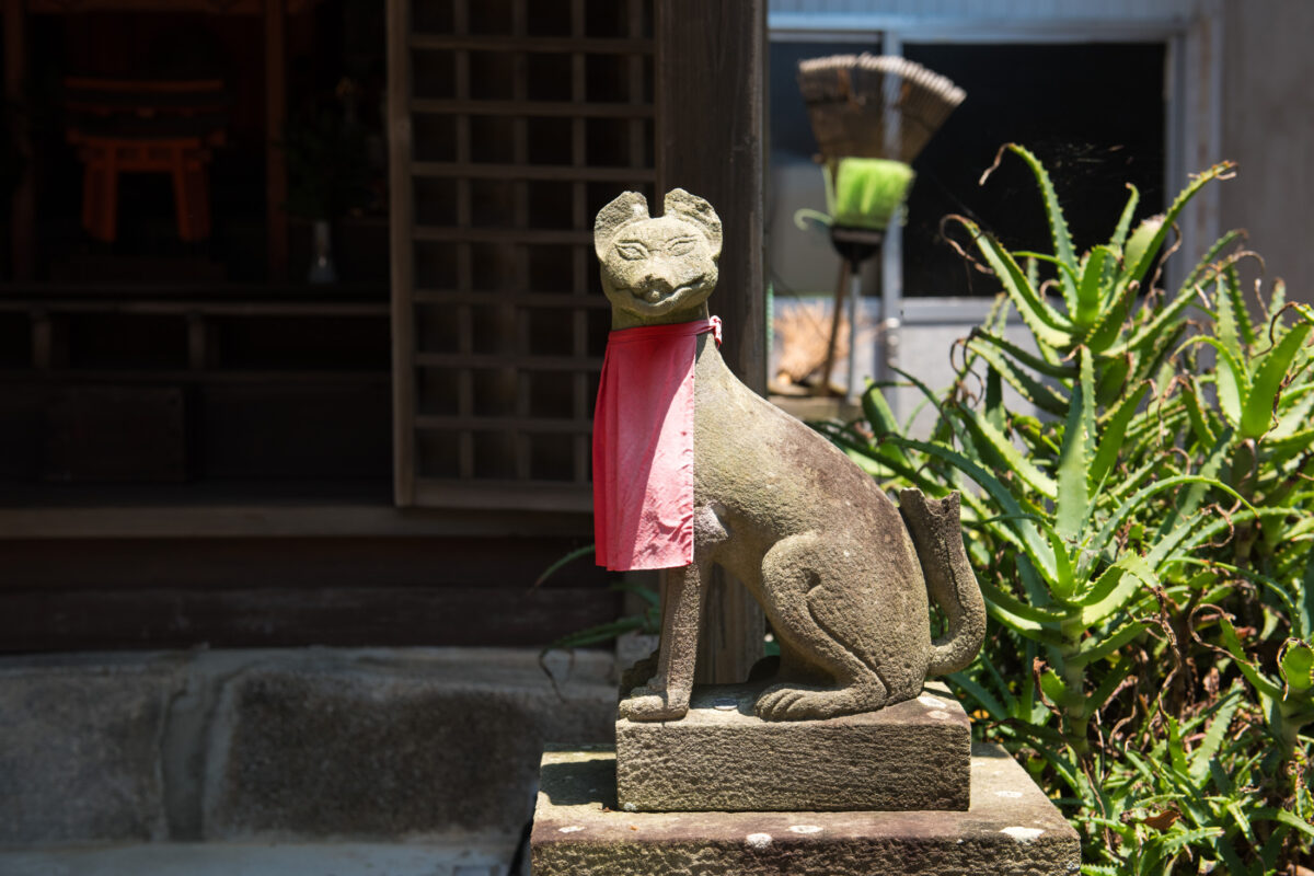 Stone guardian statue with red bib at Wakaura Tenmangu Shrine, Wakayama, Japan