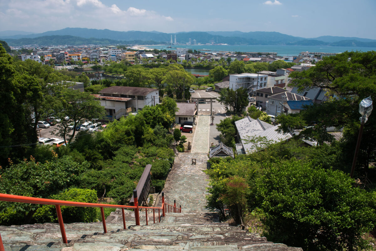 Stone staircase with red railings at Wakaura Tenmangu Shrine overlooking Wakayama coast